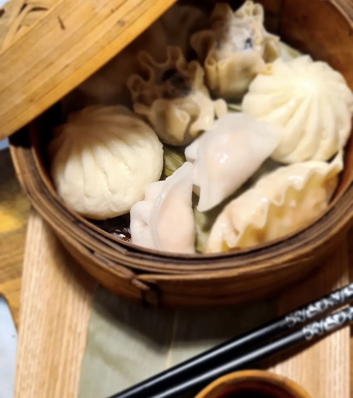 Dim sum in a bamboo steamer with chopsticks