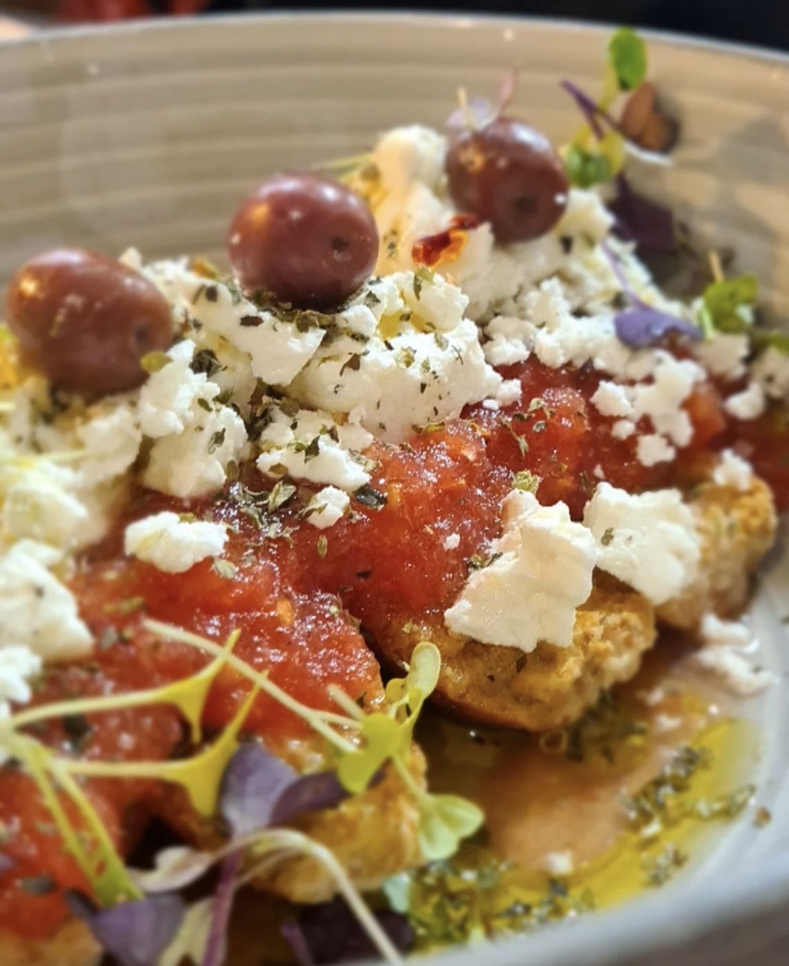Tomato, crumbled feta and olives on a rusk